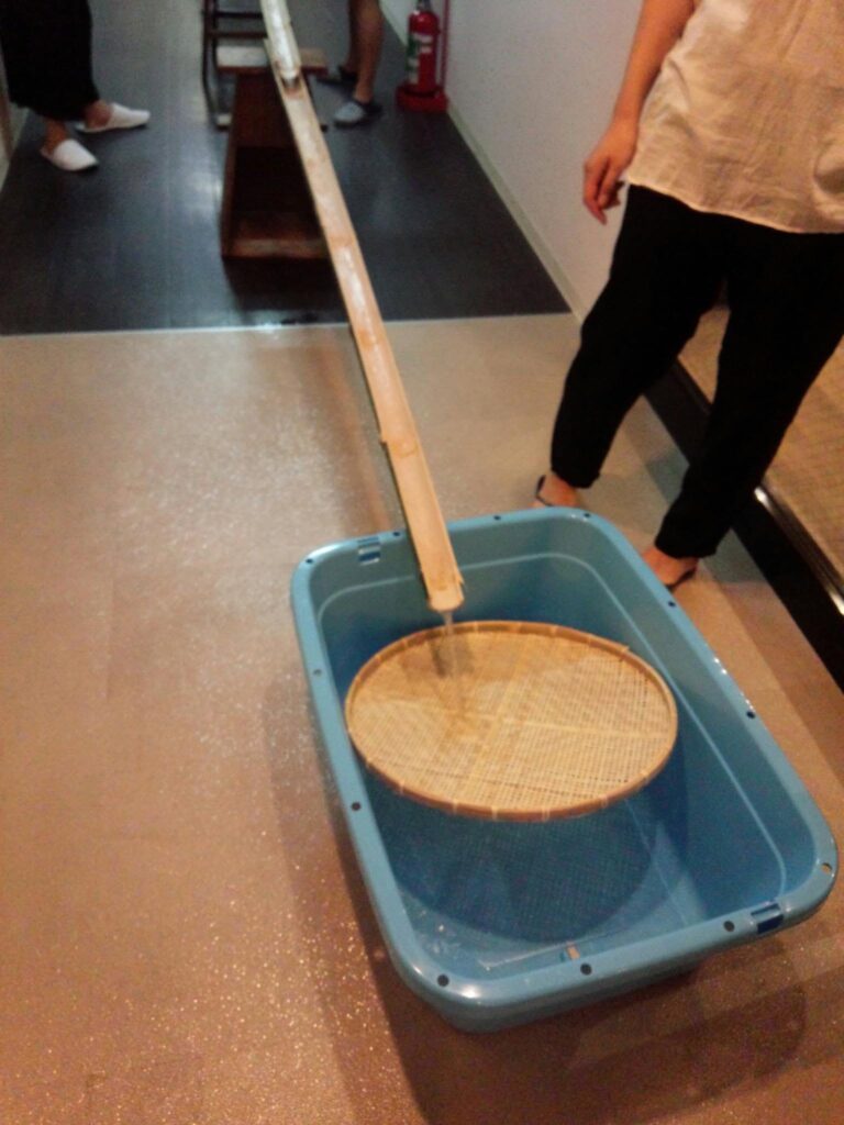 流しそうめんの竹の先に置かれたざる